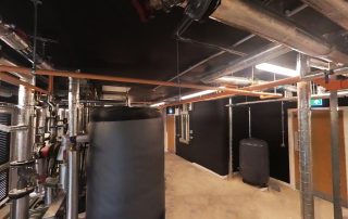 bolier room with pipes, boiler cylinder, and ceiling lightening